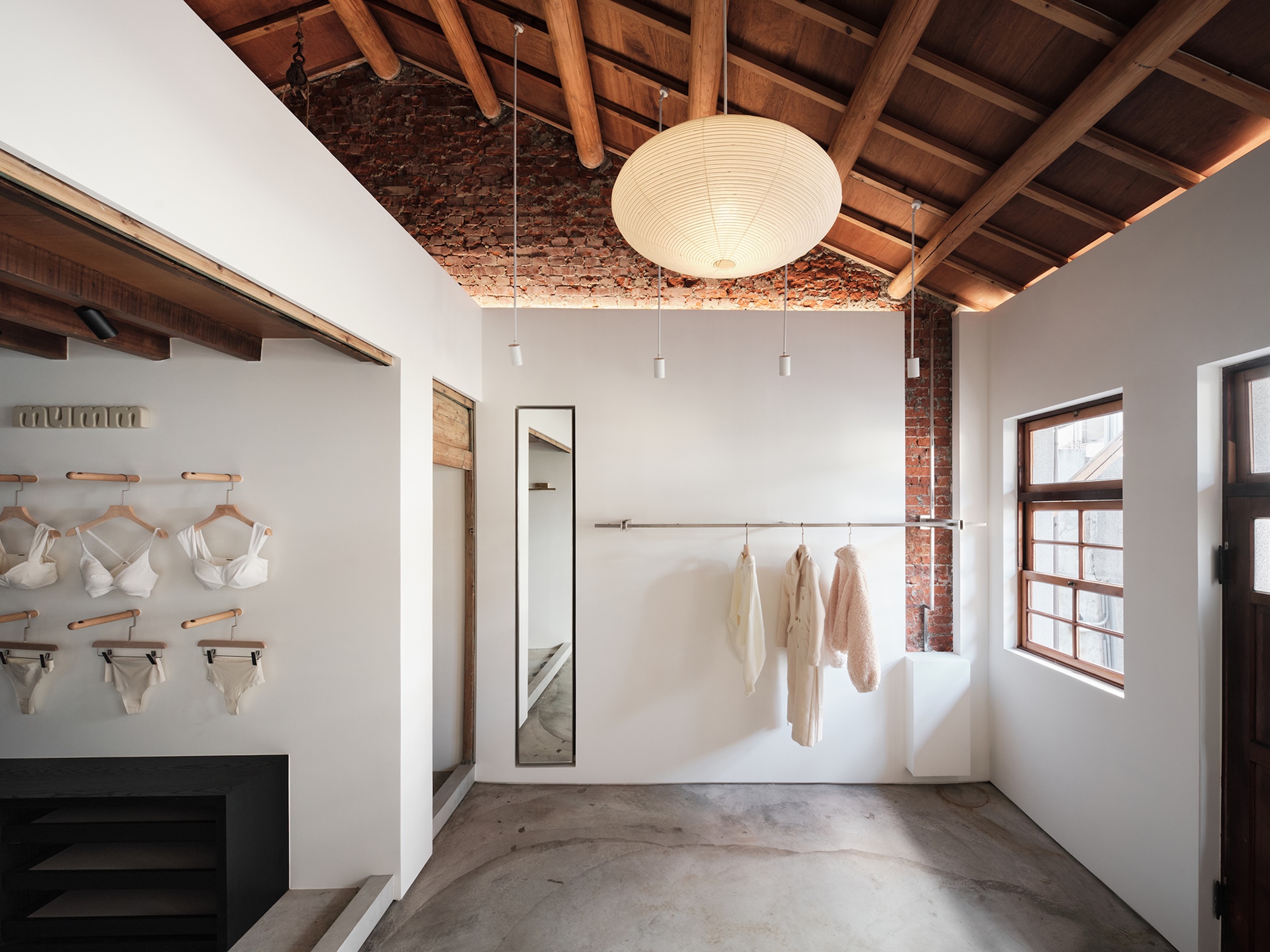 Interior view of Human Haus TN showing the juxtaposition of preserved exposed brick walls and a new, crisp white architectural volume