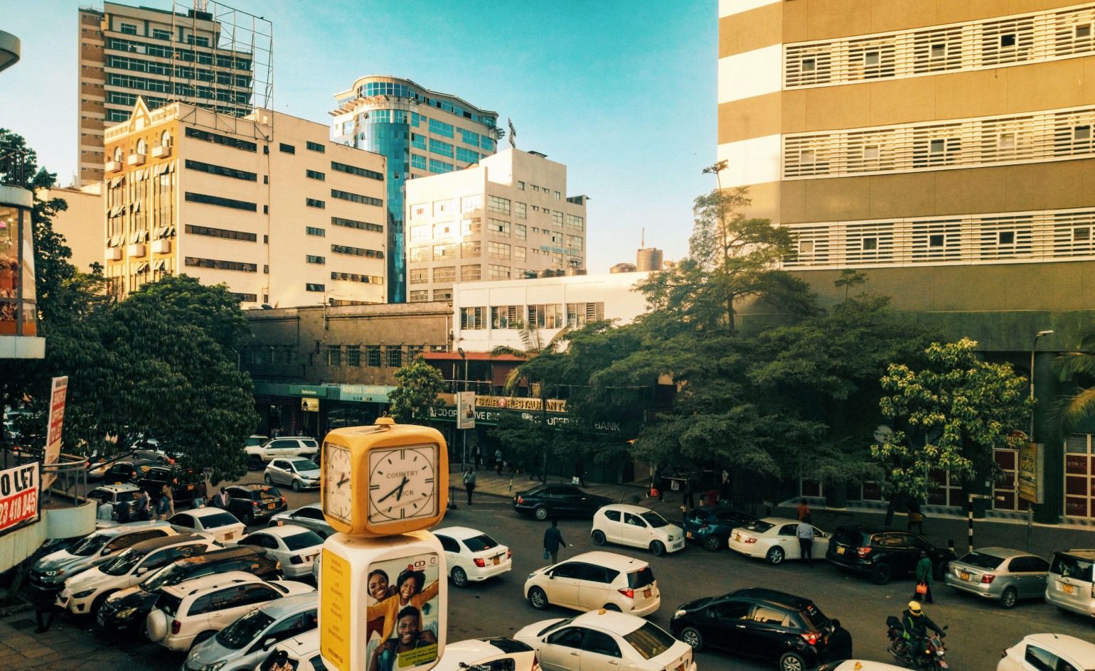 Panoramic view of Nairobi city skyline with the natural landscape of Nairobi National Park visible in the foreground, showcasing the unique juxtaposition of urban development and