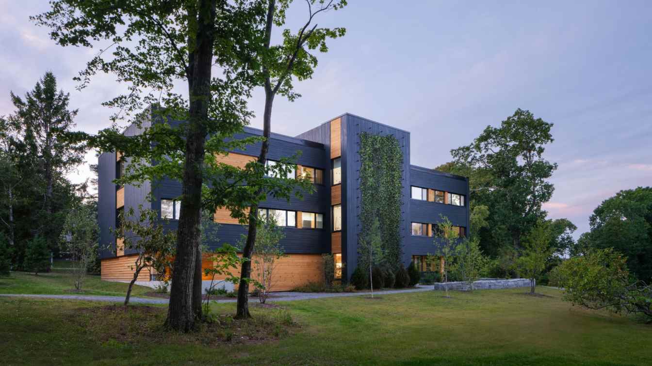 Exterior view of the Massivhaus student housing building at the College of the Atlantic, featuring a prominent timber structure.