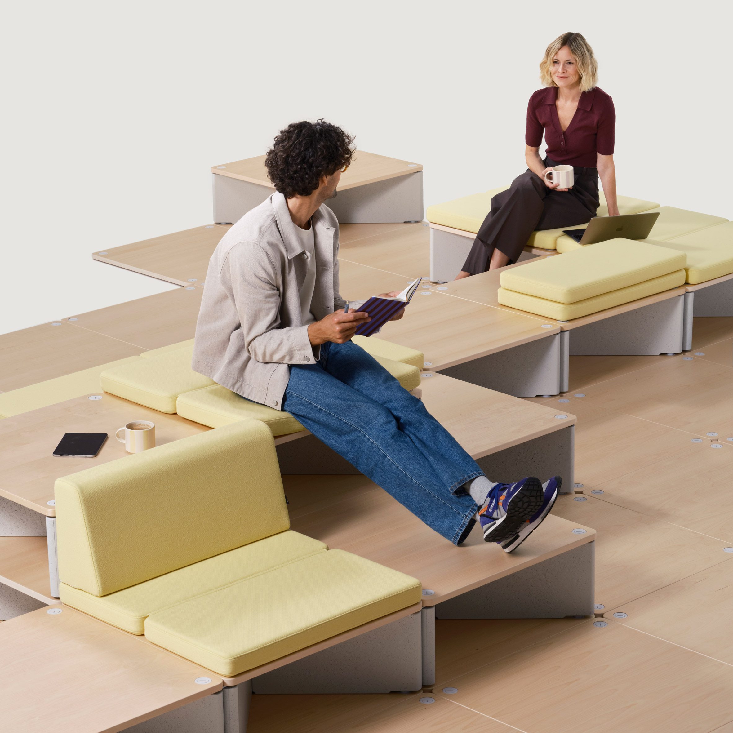 Vitra Reset modular furniture system composed of stepped platforms and cushions in a modern office setting, showcasing flexible configurations for collaboration and individual
