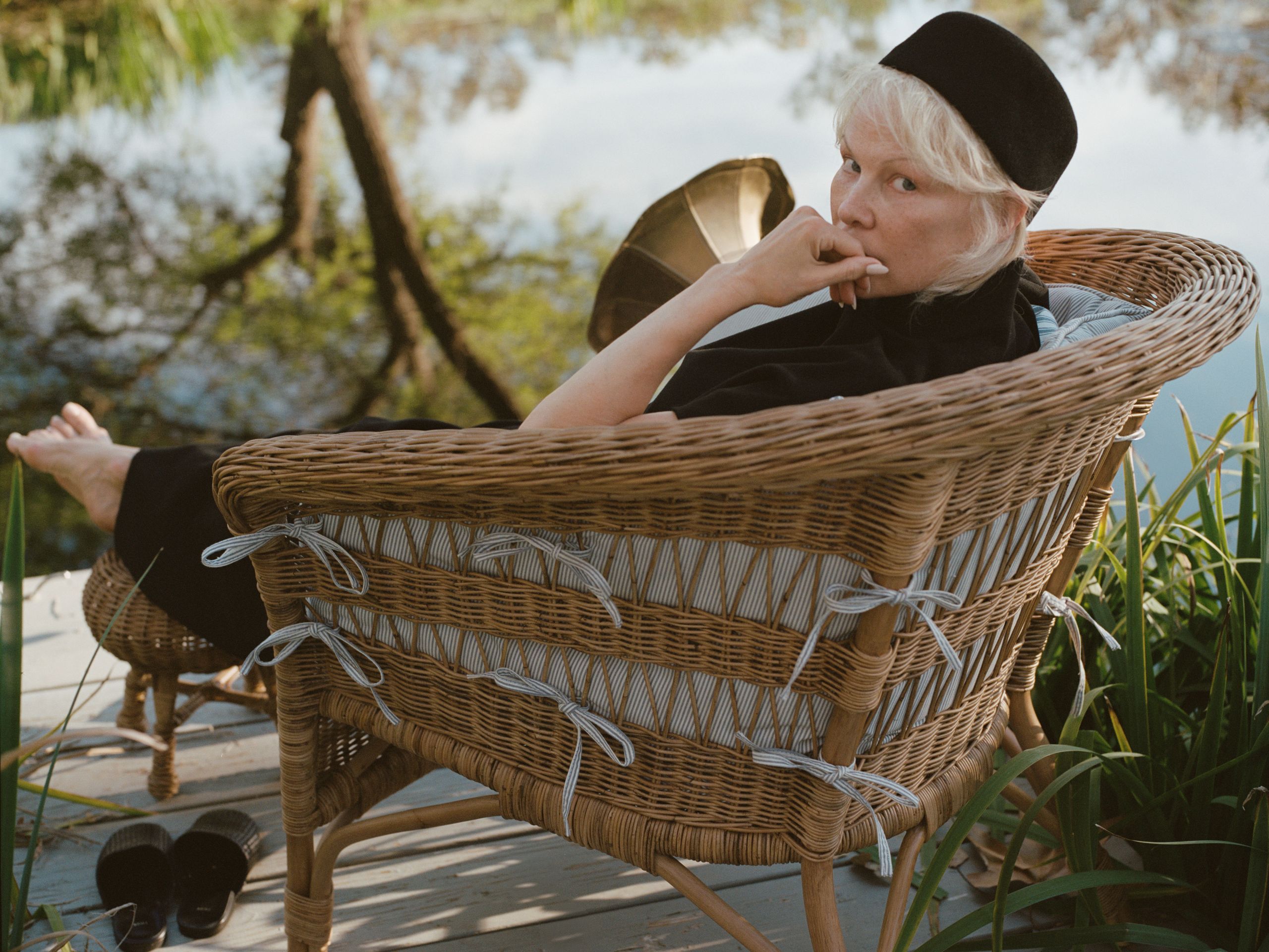 Pamela Anderson in her garden on Vancouver Island, surrounded by plants and natural elements.