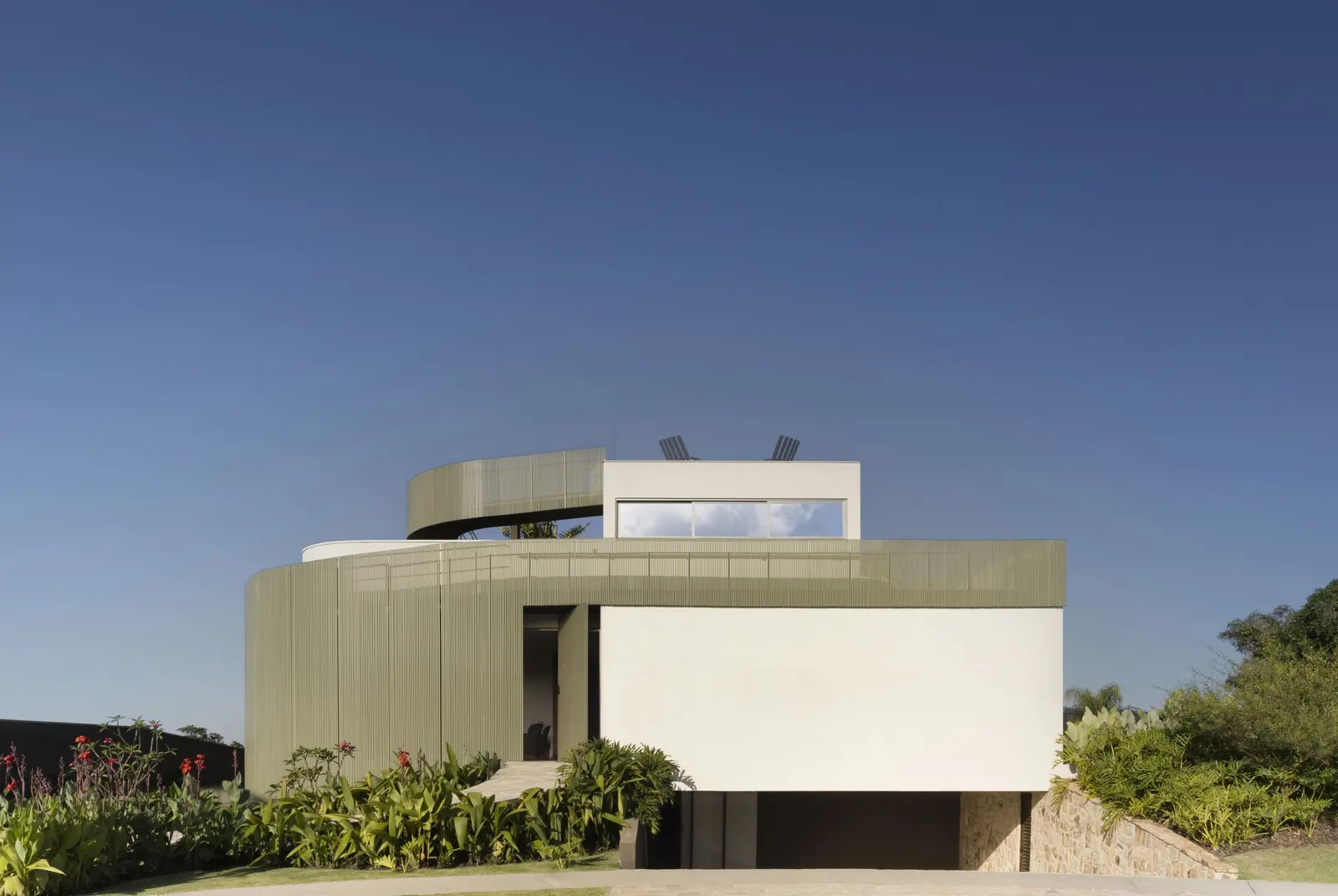 Exterior view of Casa Circular, a circular residence in Brazil with a visible spiral ramp system.