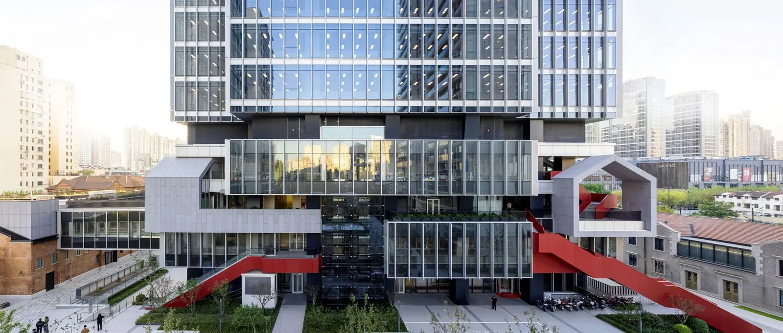 Aerial view of the Jing'An Investment Center, showcasing a modern super-high-rise tower adjacent to preserved historic low-rise buildings.