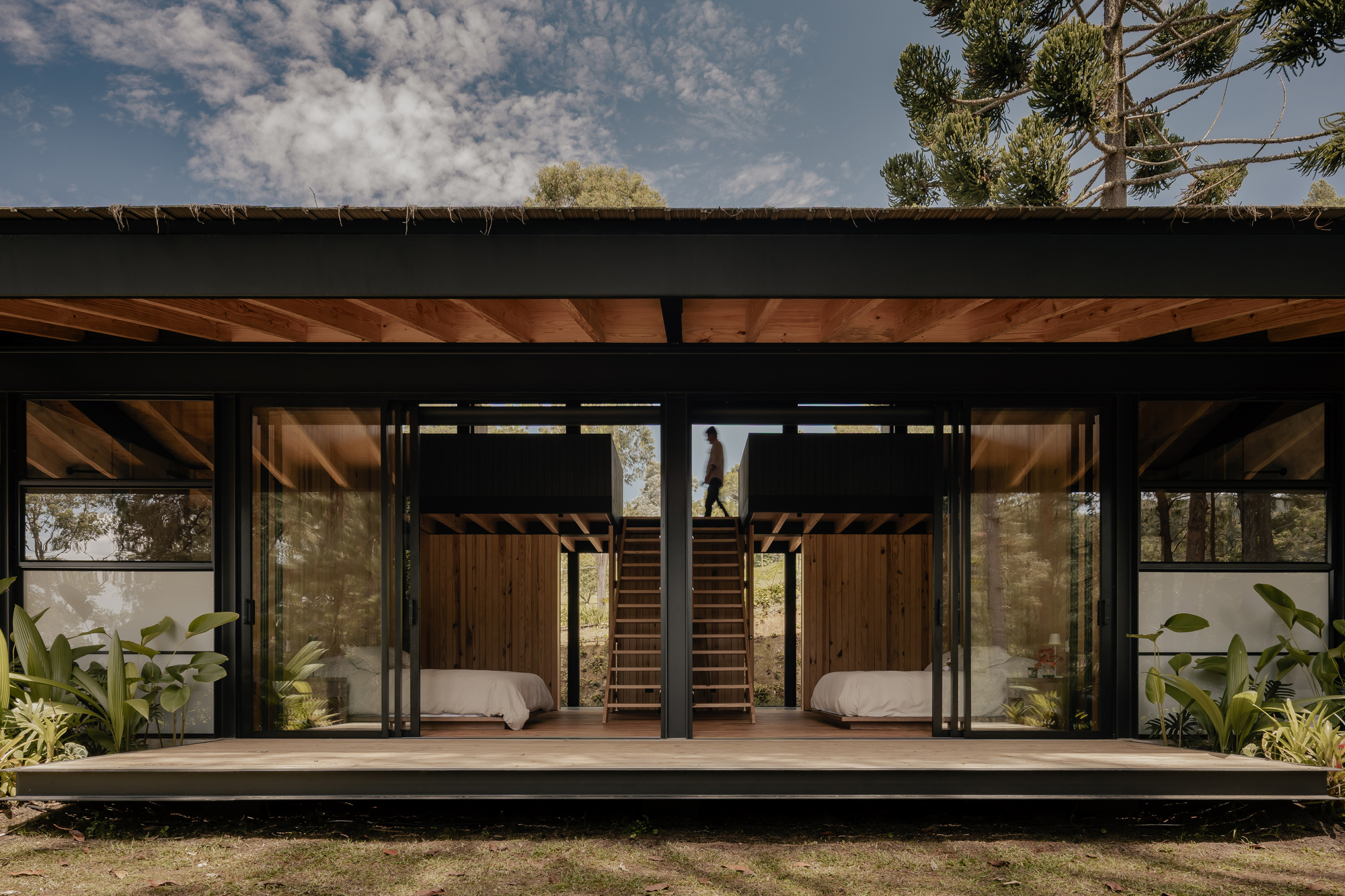 Exterior view of Casa na Represa, showcasing its integration with the surrounding natural environment and reservoir.