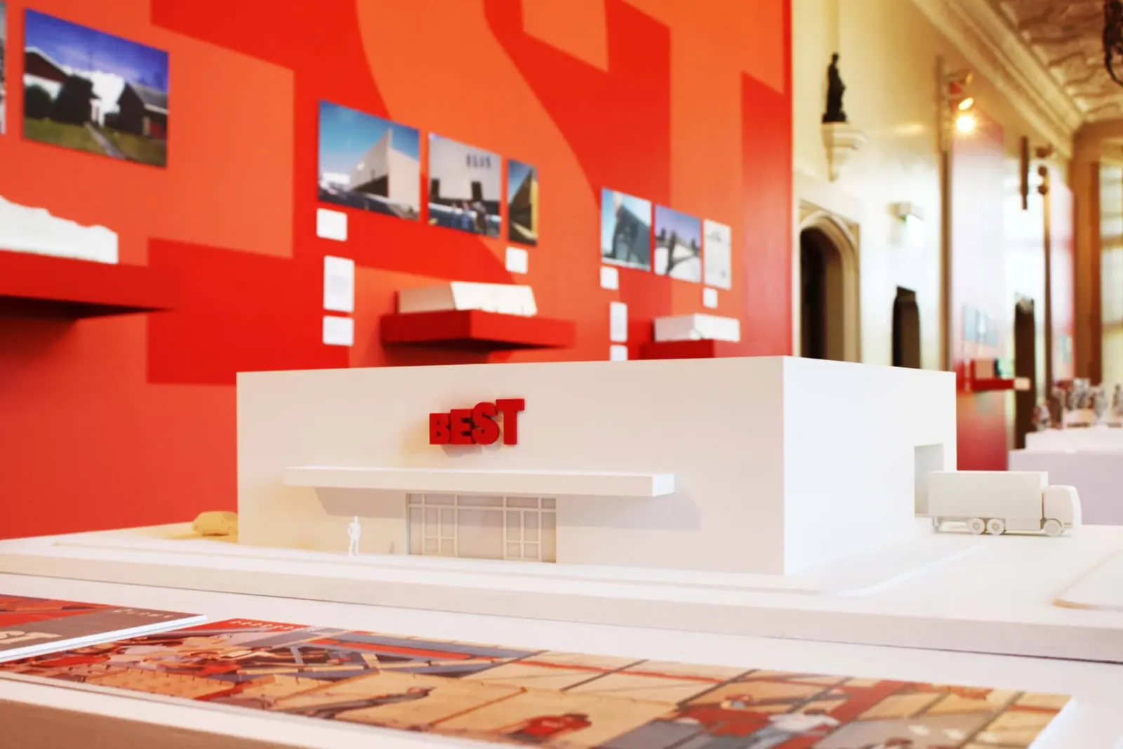 Architectural models and drawings of Best Products showrooms displayed in an exhibition space.