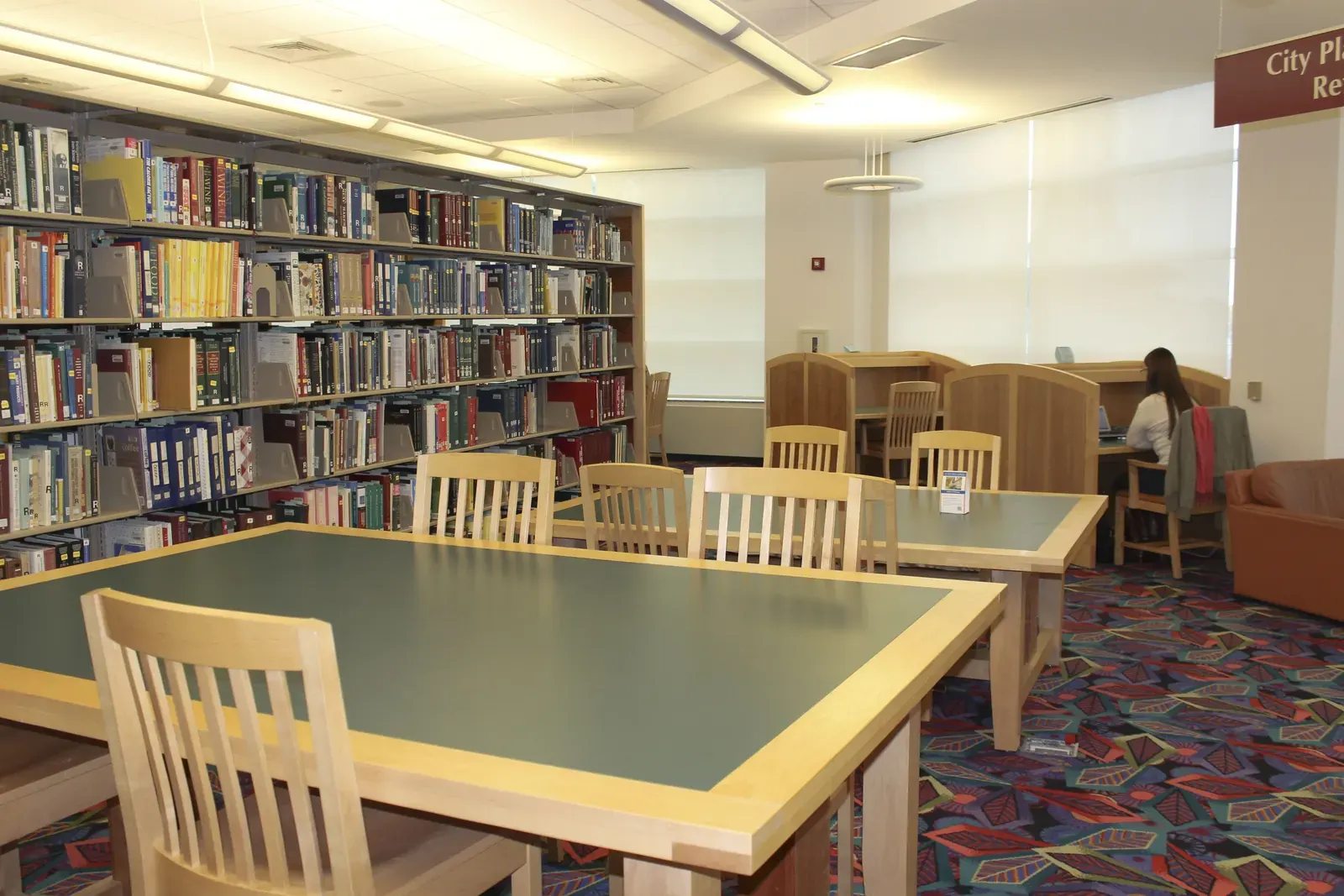 Interior view of the Toronto Metropolitan University School of Medicine, showcasing wood-clad structural elements and vibrant blue seating areas.