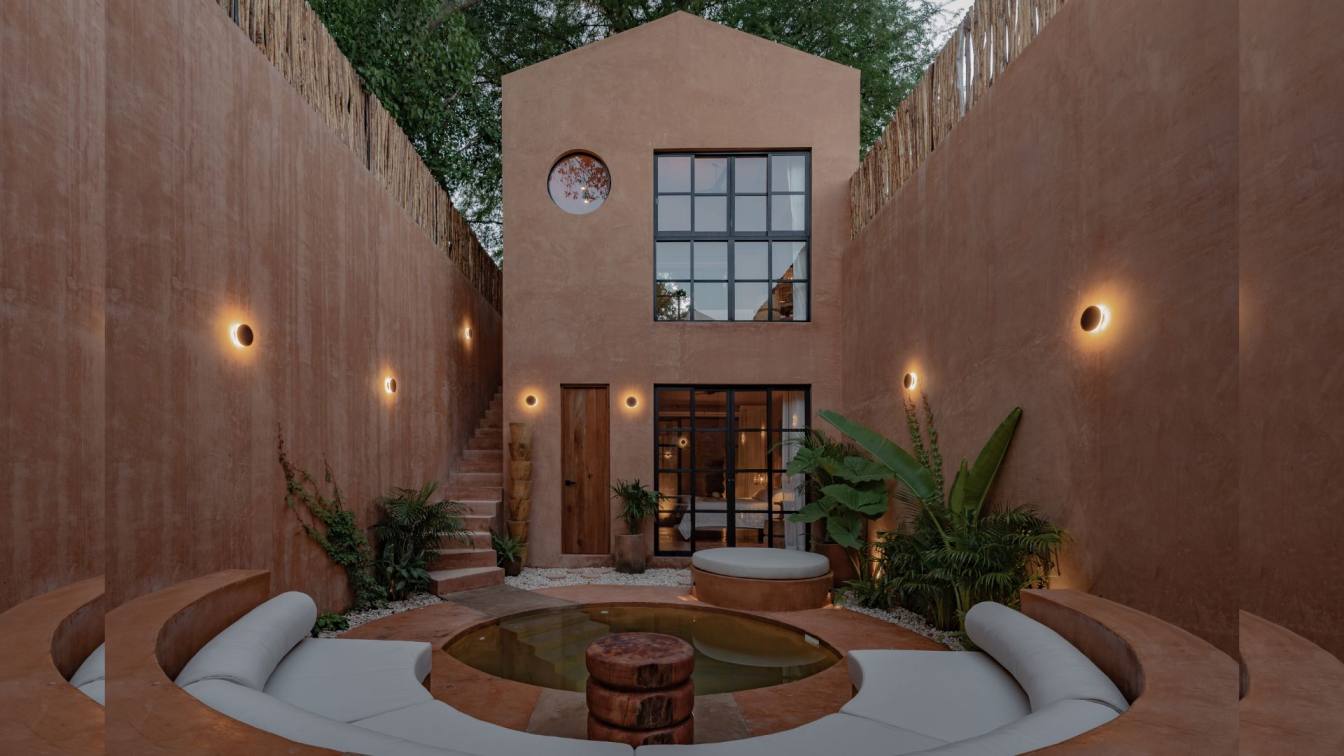 Exterior view of Casa Skoura, a desert-inspired home in Yucatán, Mexico, with earthy tones and integrated ruins.