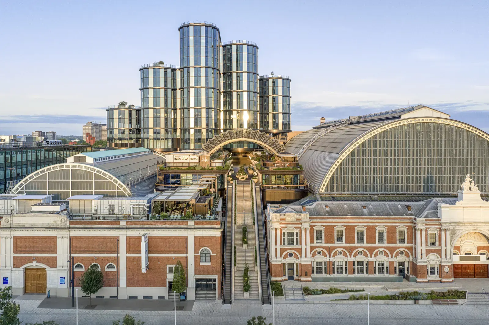A view of the newly unveiled public canopy at Olympia, West London, designed by Heatherwick Studio and SPPARC, with views of the historic roofscape.