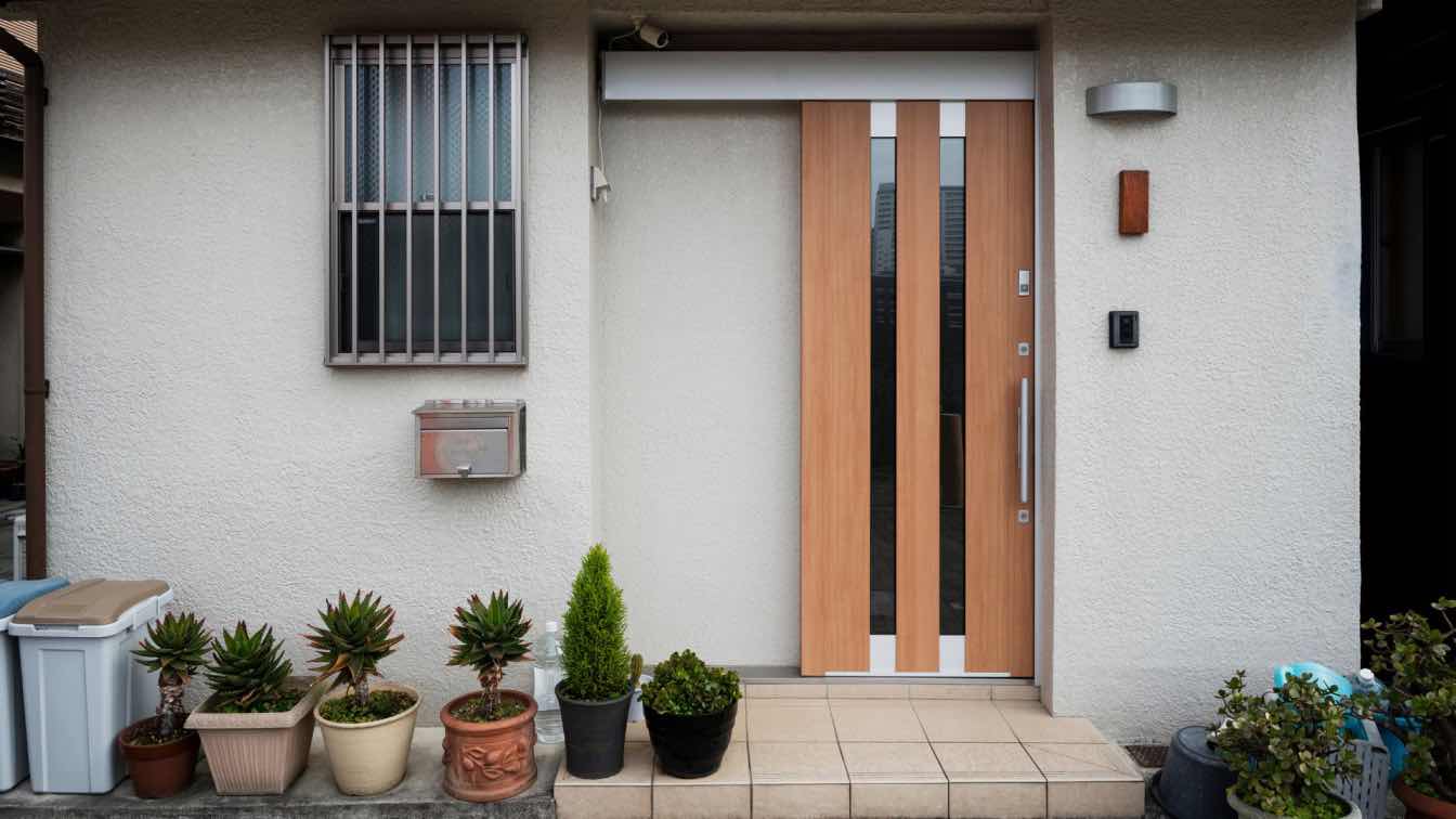 A contemporary house facade featuring a sleek, modern front door with clean lines and a sophisticated finish.
