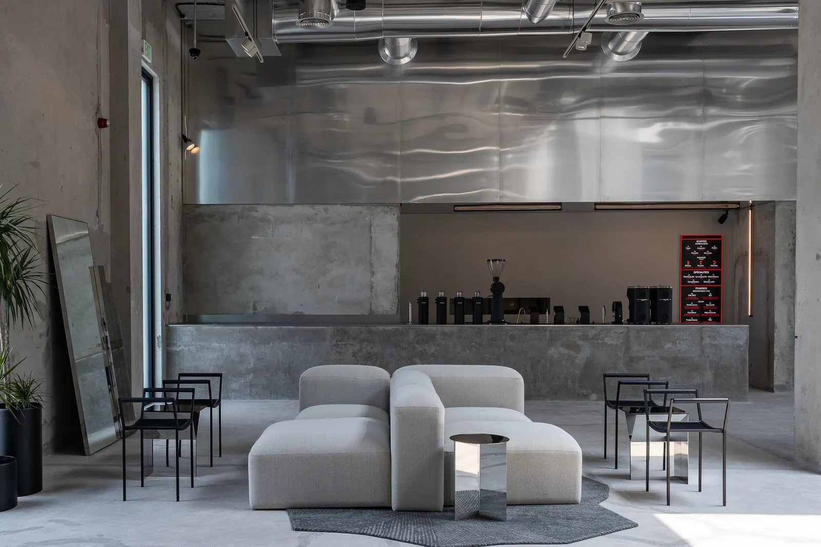 Interior of Koncrete Space, a Dubai venue featuring a coffee bar, curated retail displays, and communal seating areas.