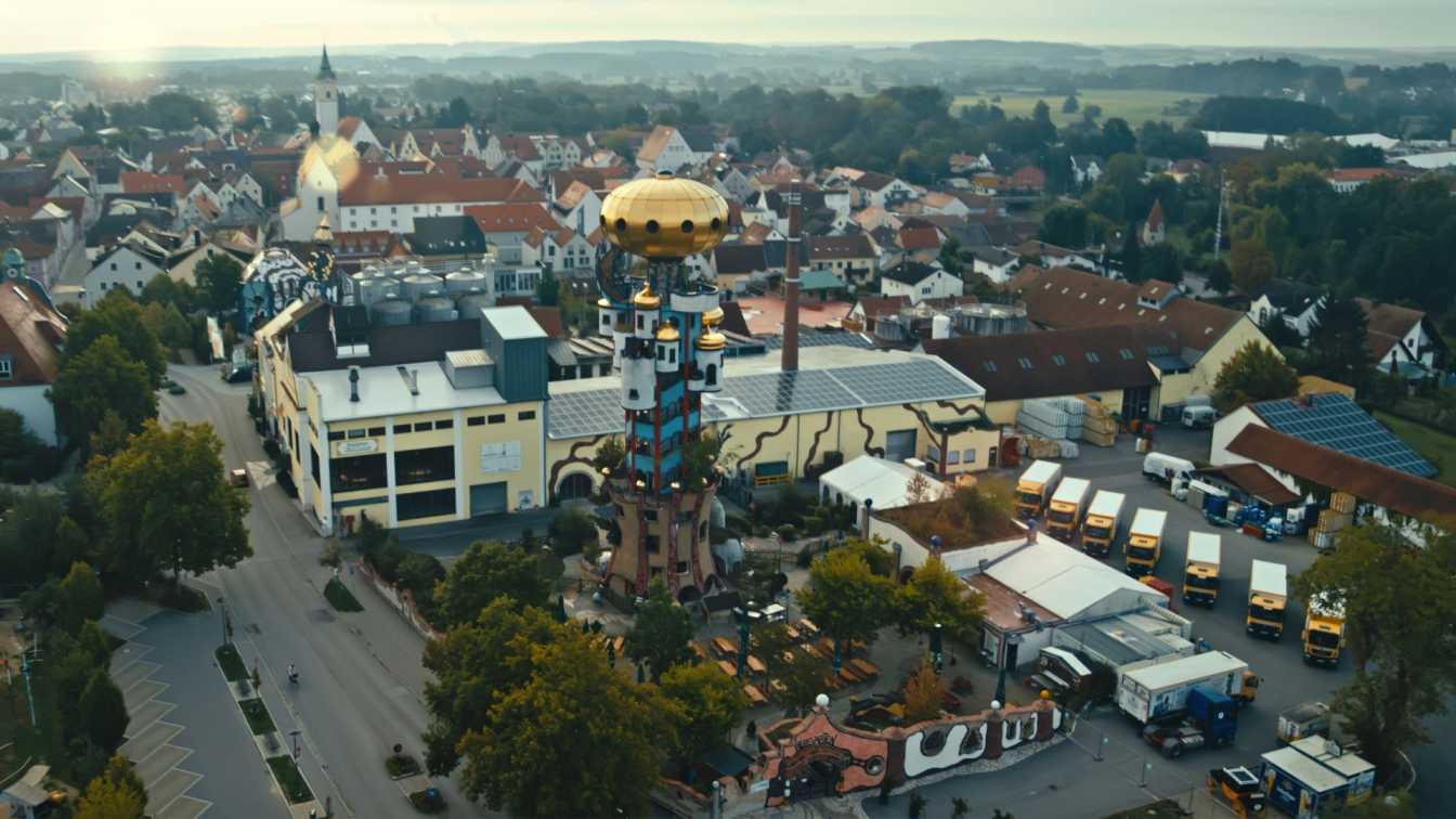 The colorful and uniquely shaped Kuchlbauer Tower, with its onion dome, stands tall against a blue sky.