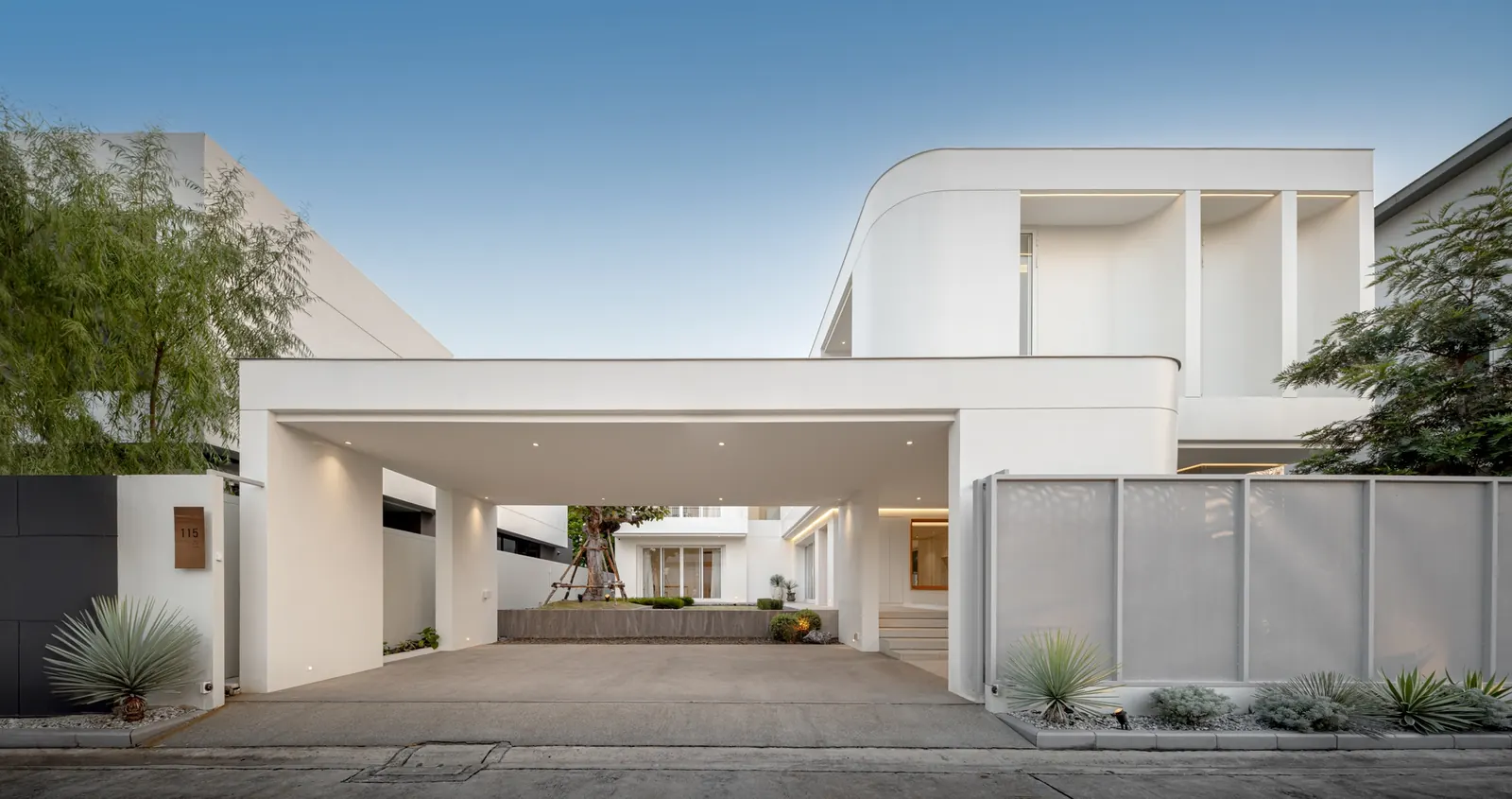 Exterior view of the JNG House, showcasing its minimalist design with concrete and glass elements.