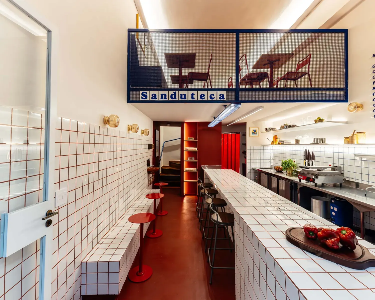 Interior of Sanduteca sandwich library in Galeria Metrópole, São Paulo, featuring a blend of vintage and contemporary design with shelves of spices and books.