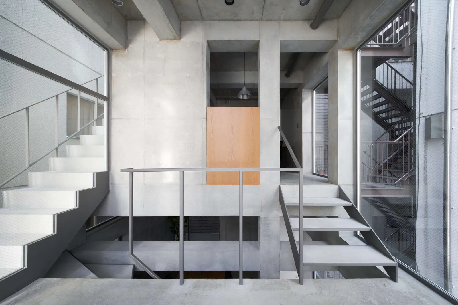 The Koenji Office Building by SO&CO features a minimalist concrete facade on a narrow urban lot.
