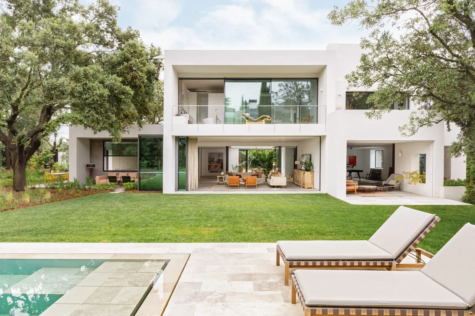 Interior view of the renovated LVL house by Ábaton in Madrid, showing open living spaces with wood and glass finishes