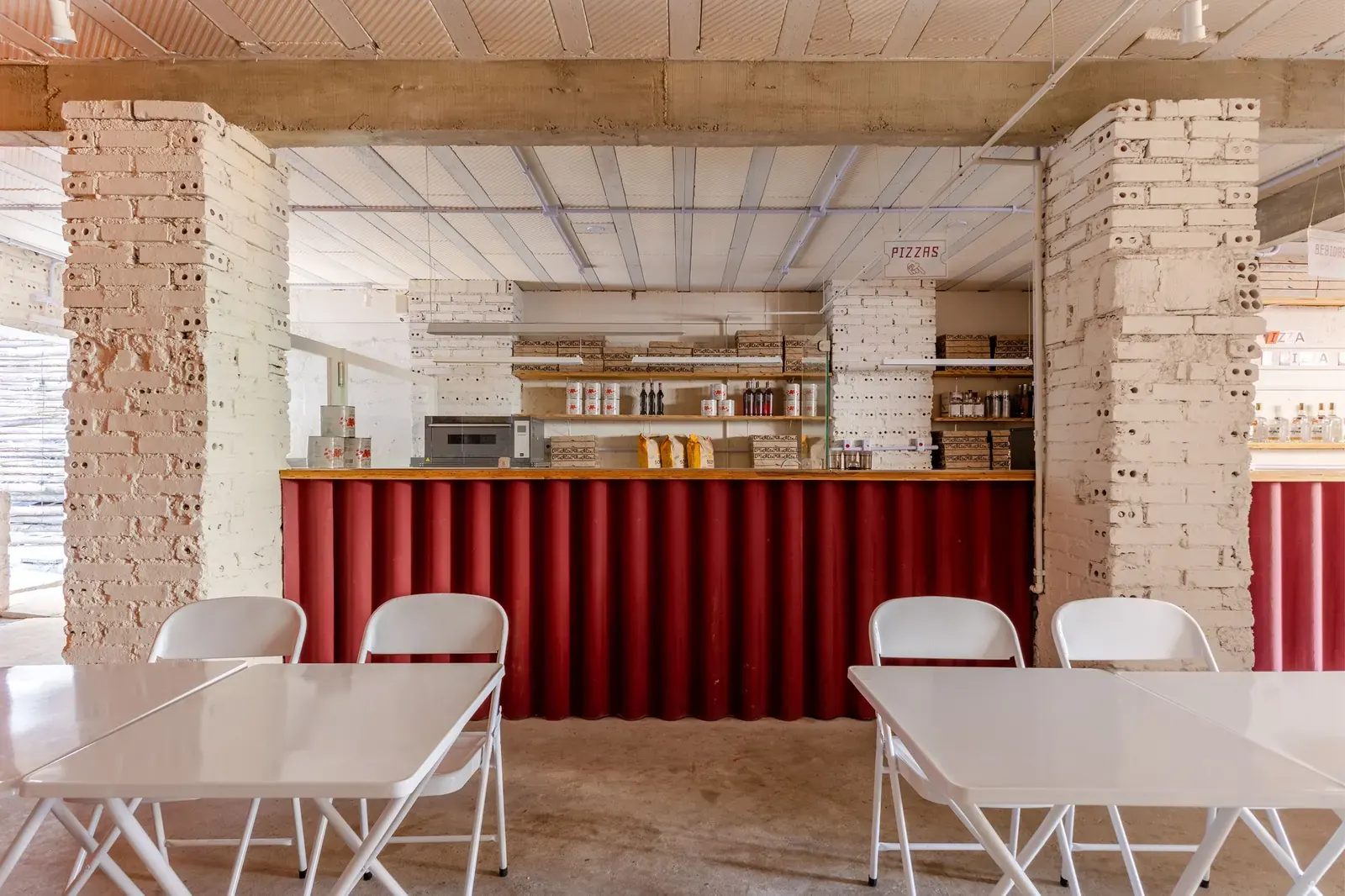 Cença Pizza Bar interior with exposed brick and warm lighting, designed by IN arq+design in Curitiba