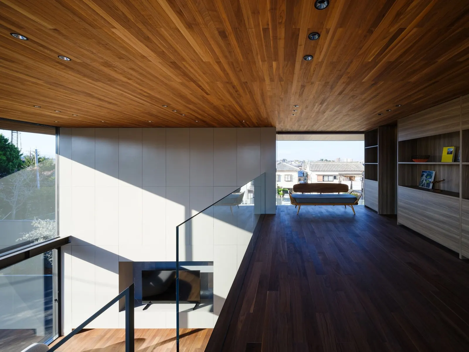 The minimalist exterior of the Moment house in Osaka, featuring a blind wall and deep timber-lined eaves, designed by Apollo Architects & Associates