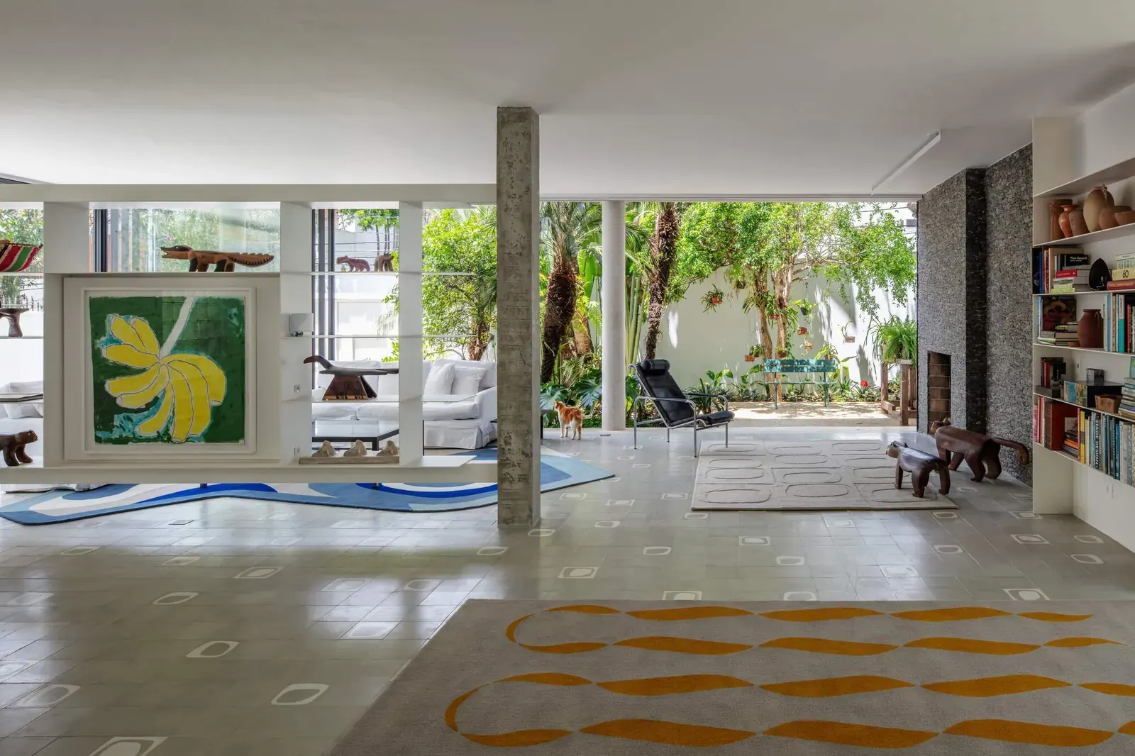 Exterior view of the Muxarabi House, highlighting its white volume elevated on pilotis and the screened veranda.