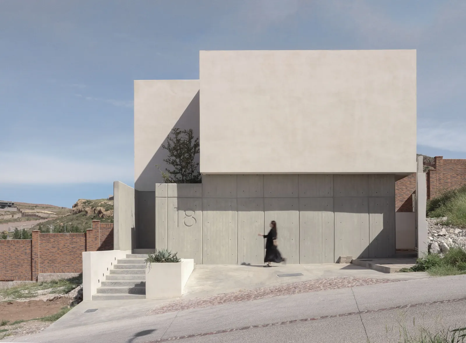 Exterior view of House Dieciocho showcasing its modern design and integration with a central courtyard.