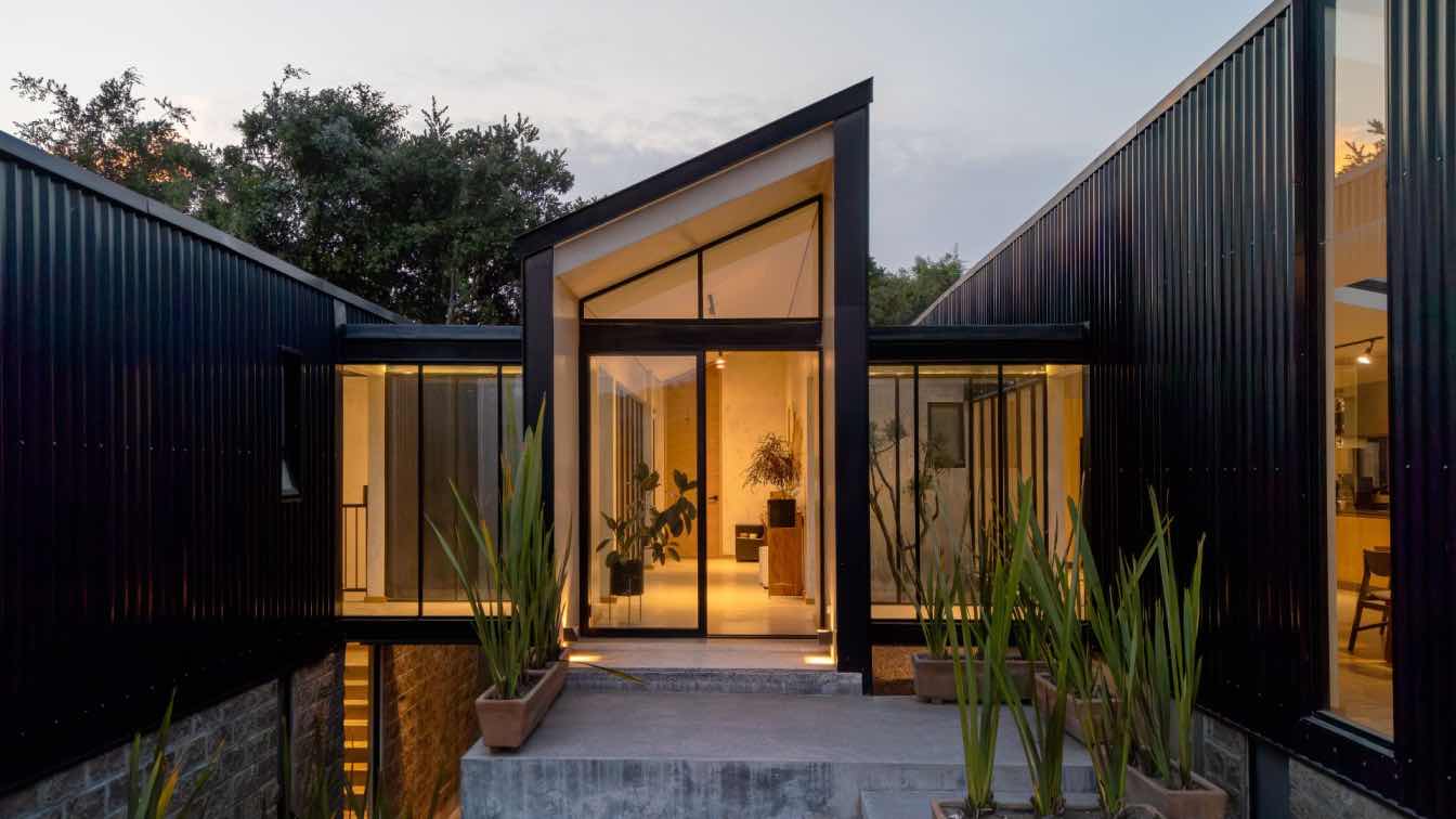 Exterior view of AE House in Puebla, Mexico, nestled within dense vegetation.