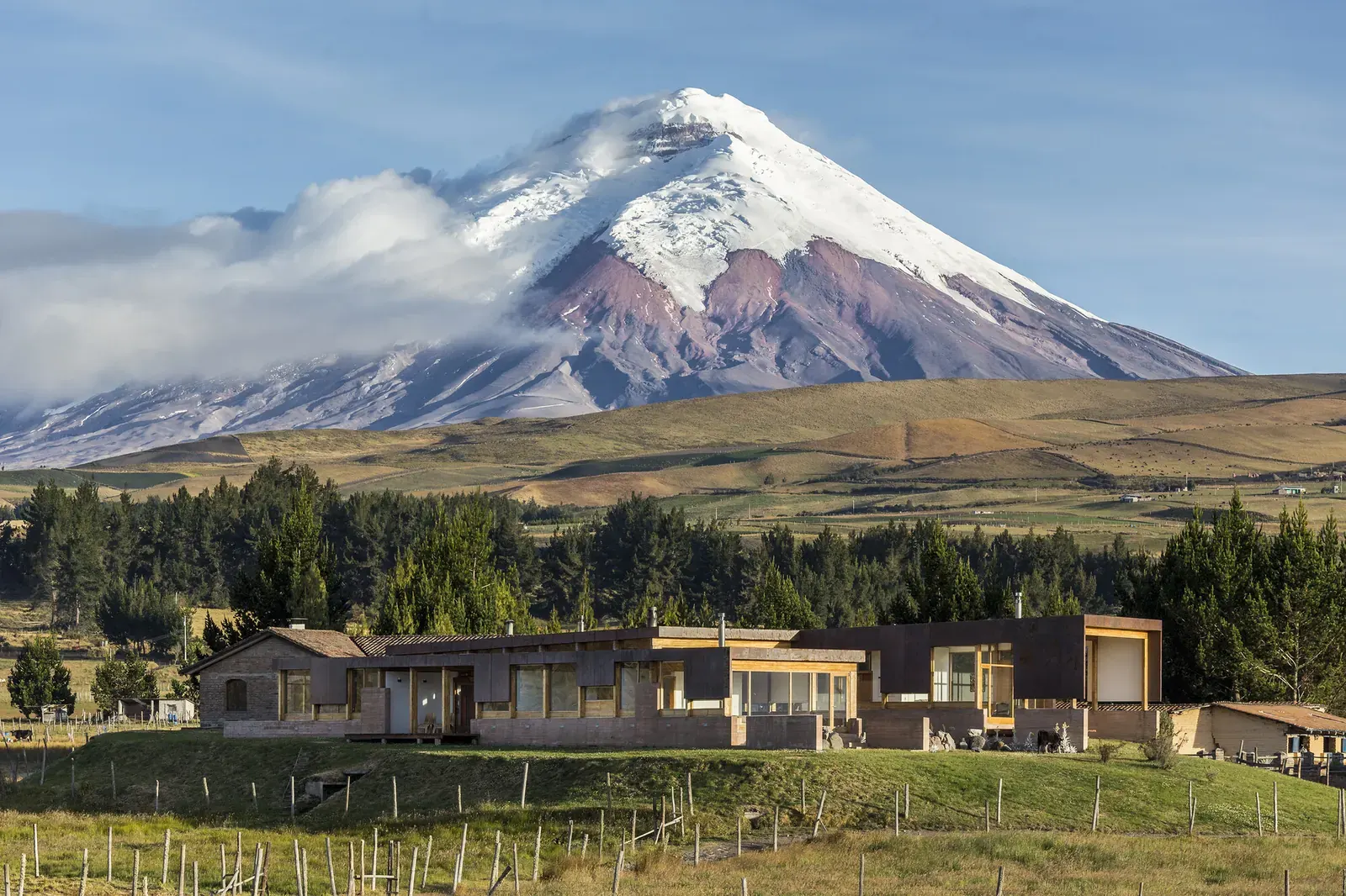 A modern house nestled in a high-altitude Andean landscape, demonstrating integration with its environment.
