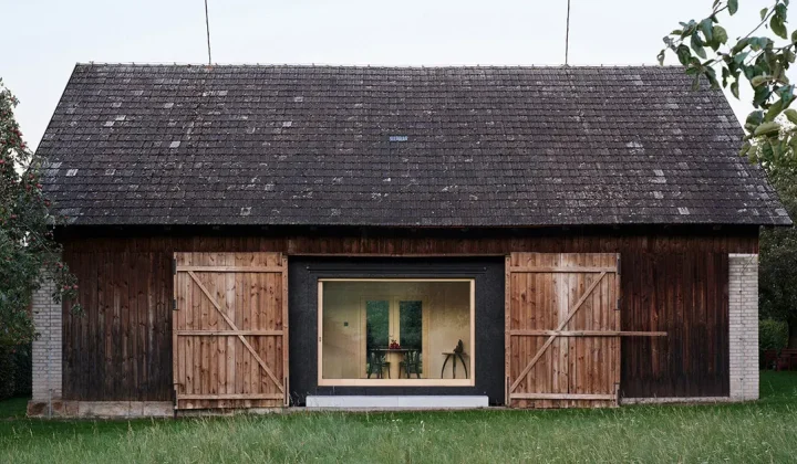 Facha architekti inserts black asphalt retreat into a Czech agricultural barn