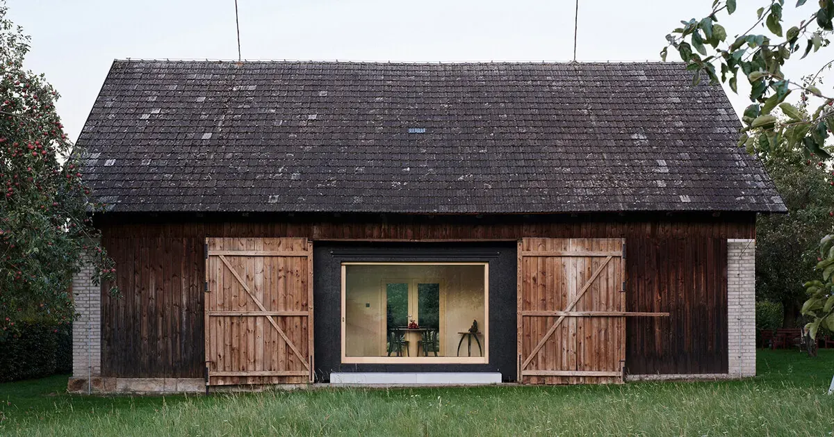 Facha architekti inserts black asphalt retreat into a Czech agricultural barn