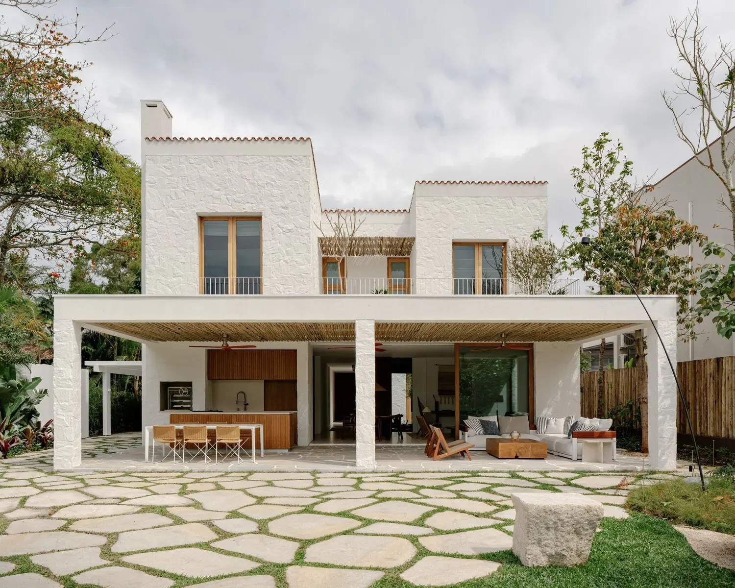 Exterior view of the Laranjeiras House, a contemporary residence with a clean facade overlooking a canal.