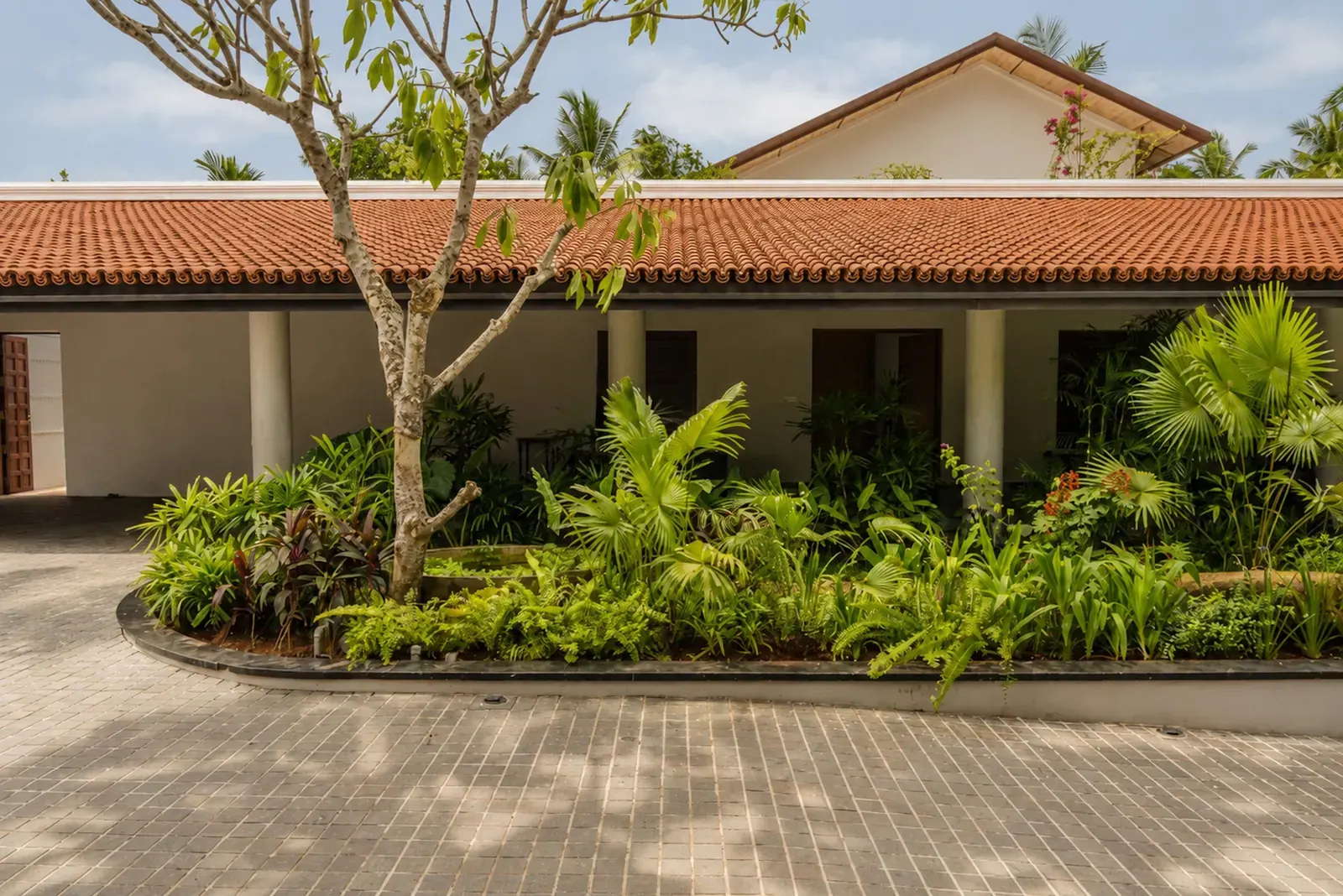 Ochre Residence exterior by Thought Parallels, featuring terracotta and timber finishes in a tropical setting