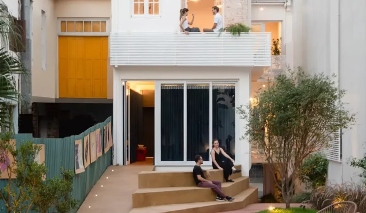 Brazilian House Reimagined as Cultural Art Hub with Exposed Brick and Blue Metal Accents