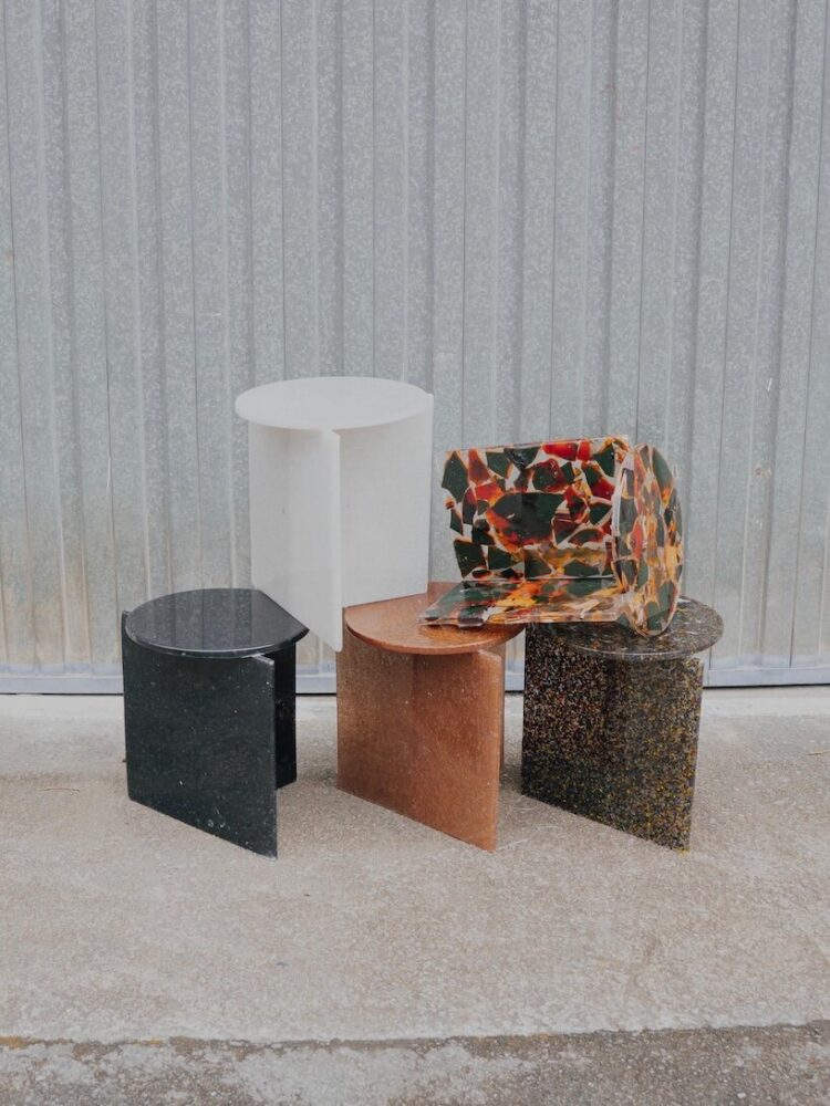 Father and daughter at their studio with finished furniture pieces made from recycled surfboard materials.