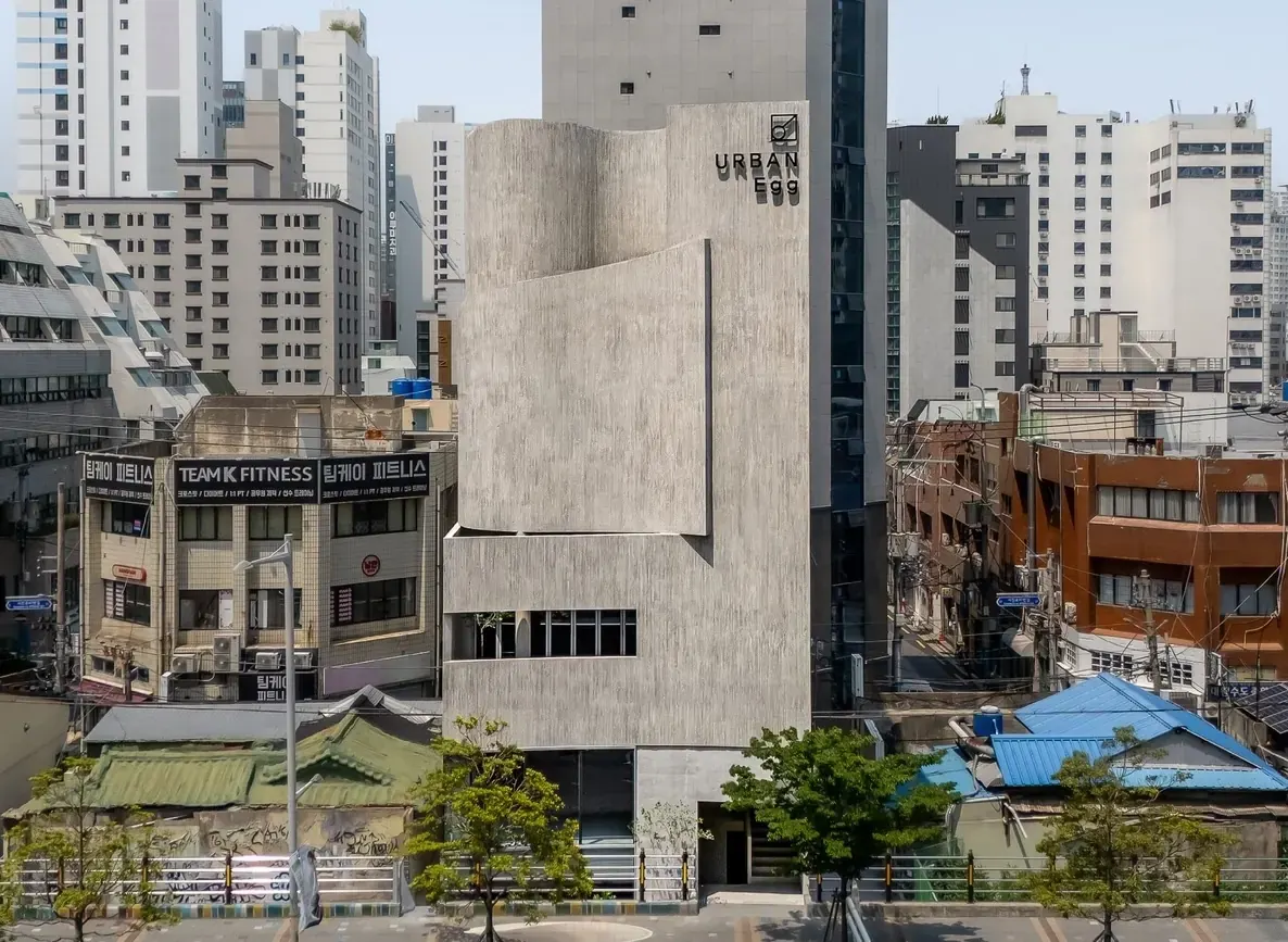 Exterior of the Urban Egg Mixed Use Facility in Busan, featuring contemporary glass elements integrated into the historical streetscape.