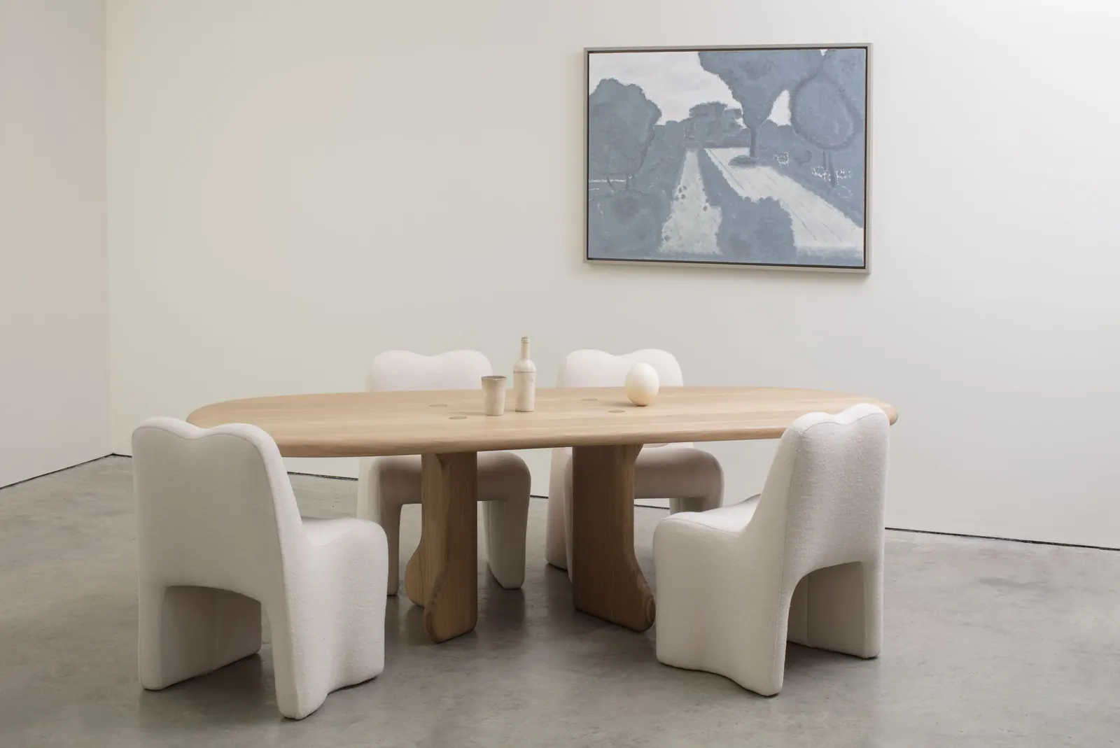 A selection of sculptural furniture pieces from Faye Toogood's 'Bone, Roll, Slump' collection, showcasing rounded forms and natural wood textures.