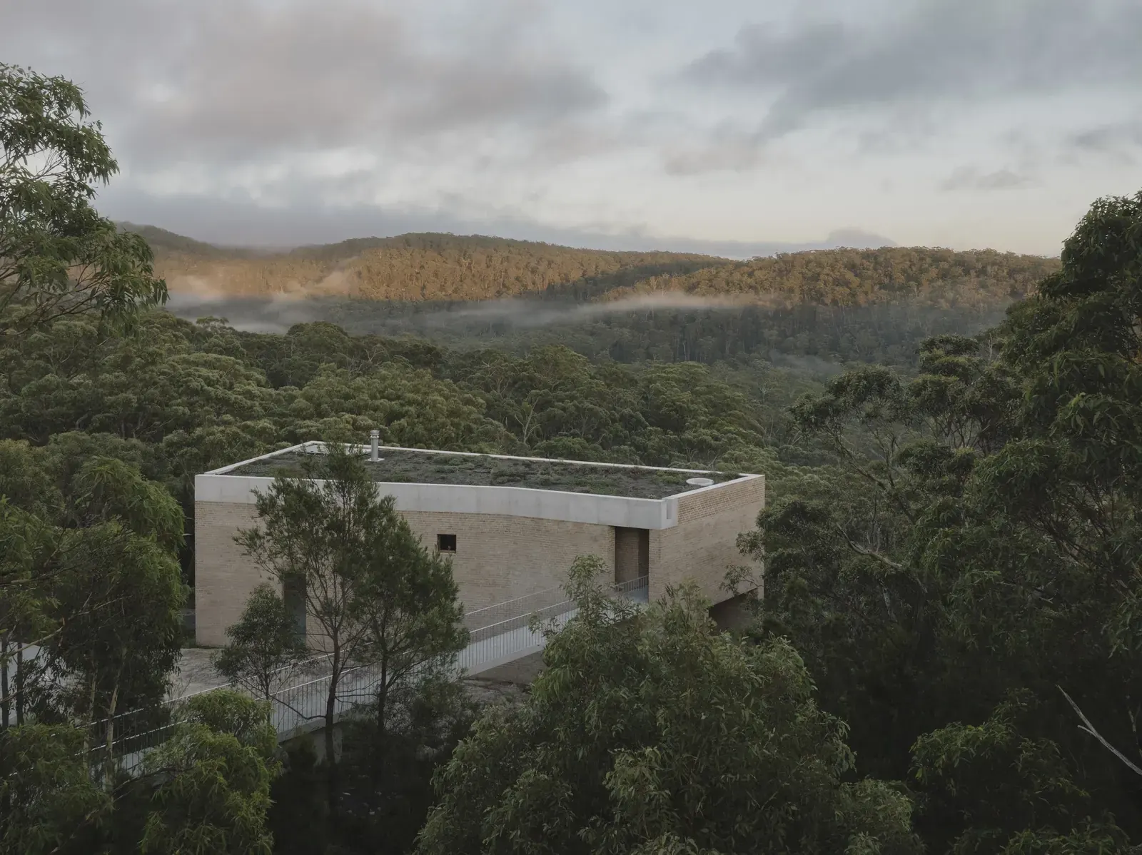 EA House, a family home by Bokey Grant, built on a rock cliff escarpment in the Southern Highlands, featuring a simple elemental form in wood and concrete