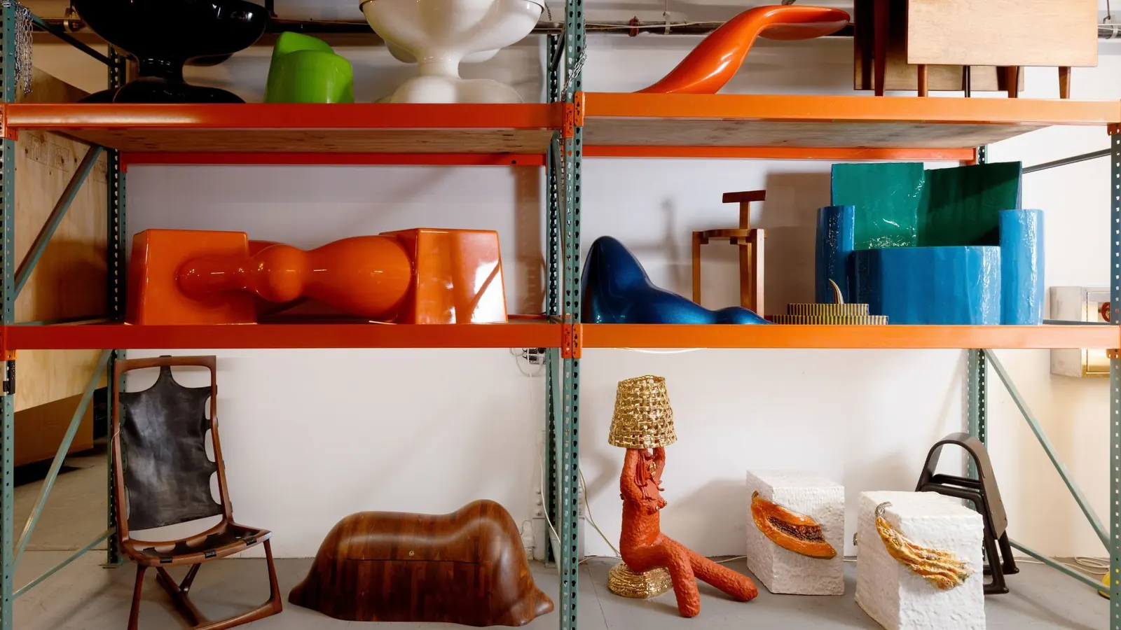 Visitors explore the newly opened R & Company design archive, Building 86, in the Brooklyn Navy Yard, with shelves displaying rare 20th and 21st century furniture and objects.