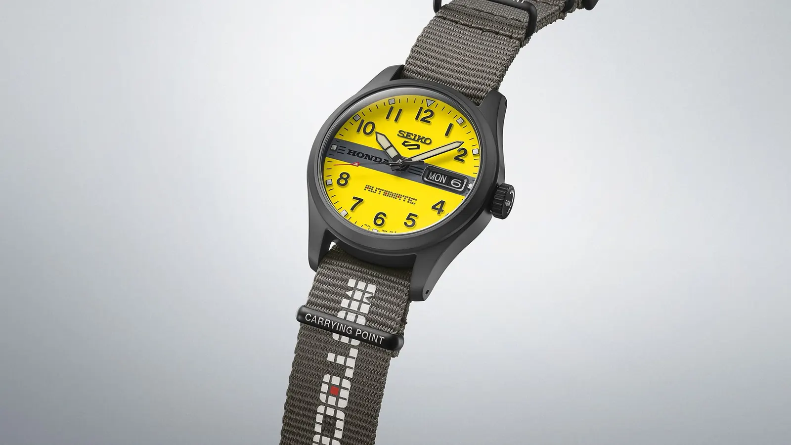 Seiko limited edition watch in yellow and black, designed to celebrate the Honda Motocompo folding scooter, shown beside the compact vehicle