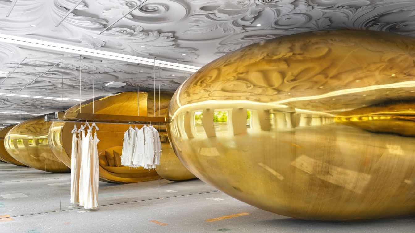 Gold chrome bean-shaped sculptural installation inside the Choux flagship store in Moscow, designed by architect Elena Lokastova