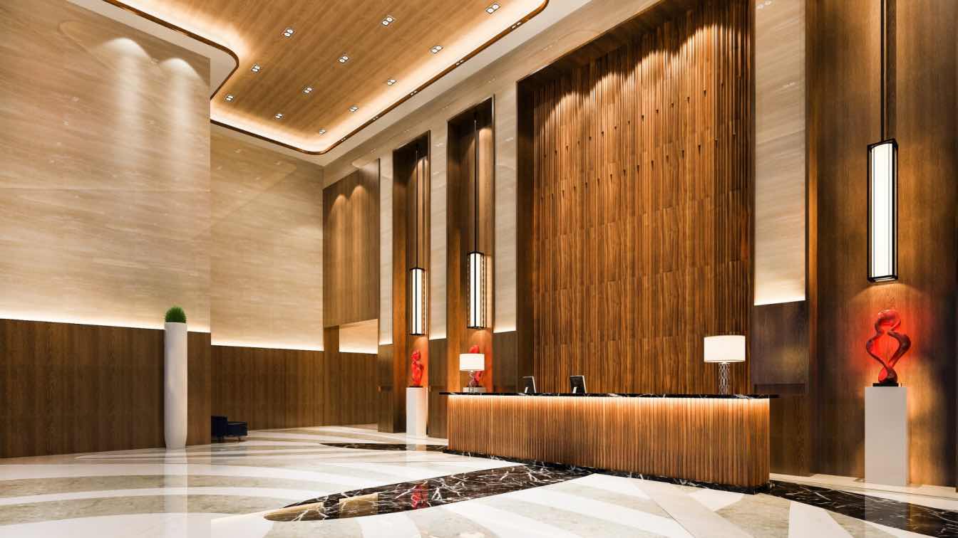 Spacious hotel lobby with moveable furniture, warm layered lighting, timber and stone surfaces, designed for flexible daytime and evening use