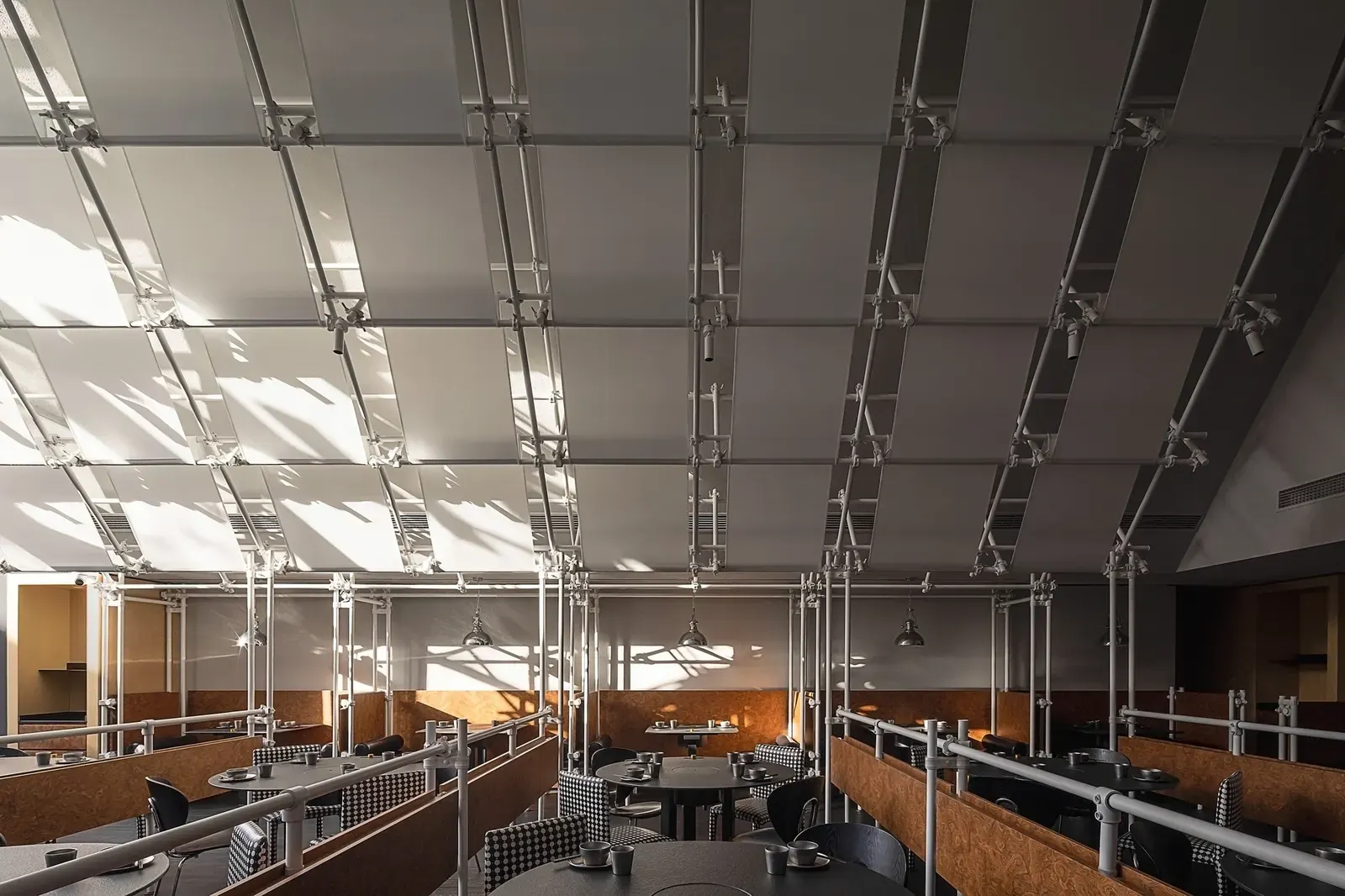 Galvanized steel scaffolding used as interior shelving and room dividers in a commercial space, with stacked items and greenery on the shelves.