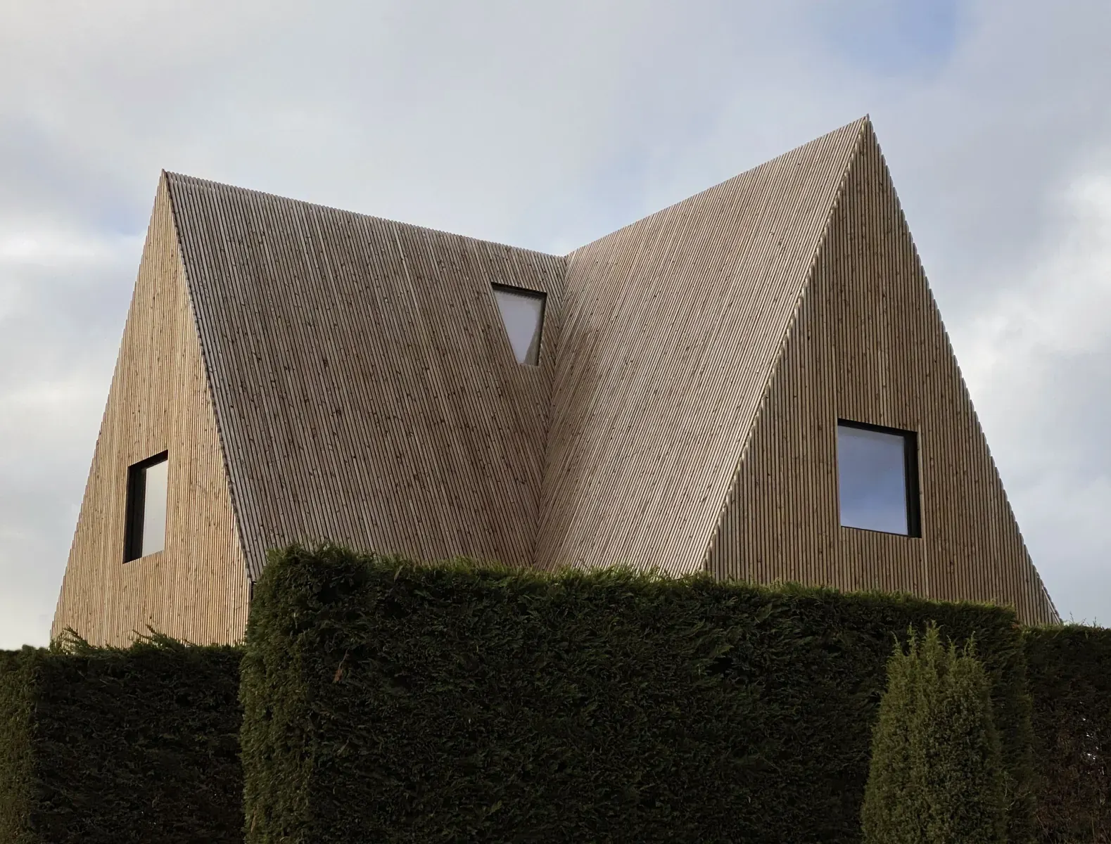 The House of Cards residence in Belgium, featuring a steeply pitched roof and seamless Douglas-fir timber cladding, designed by Vantieghem Talebi.